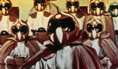 A group of eight figures with beaks for noses, and dressed in red and white outfits and helmets, stand in an imposing formation against a yellow background.