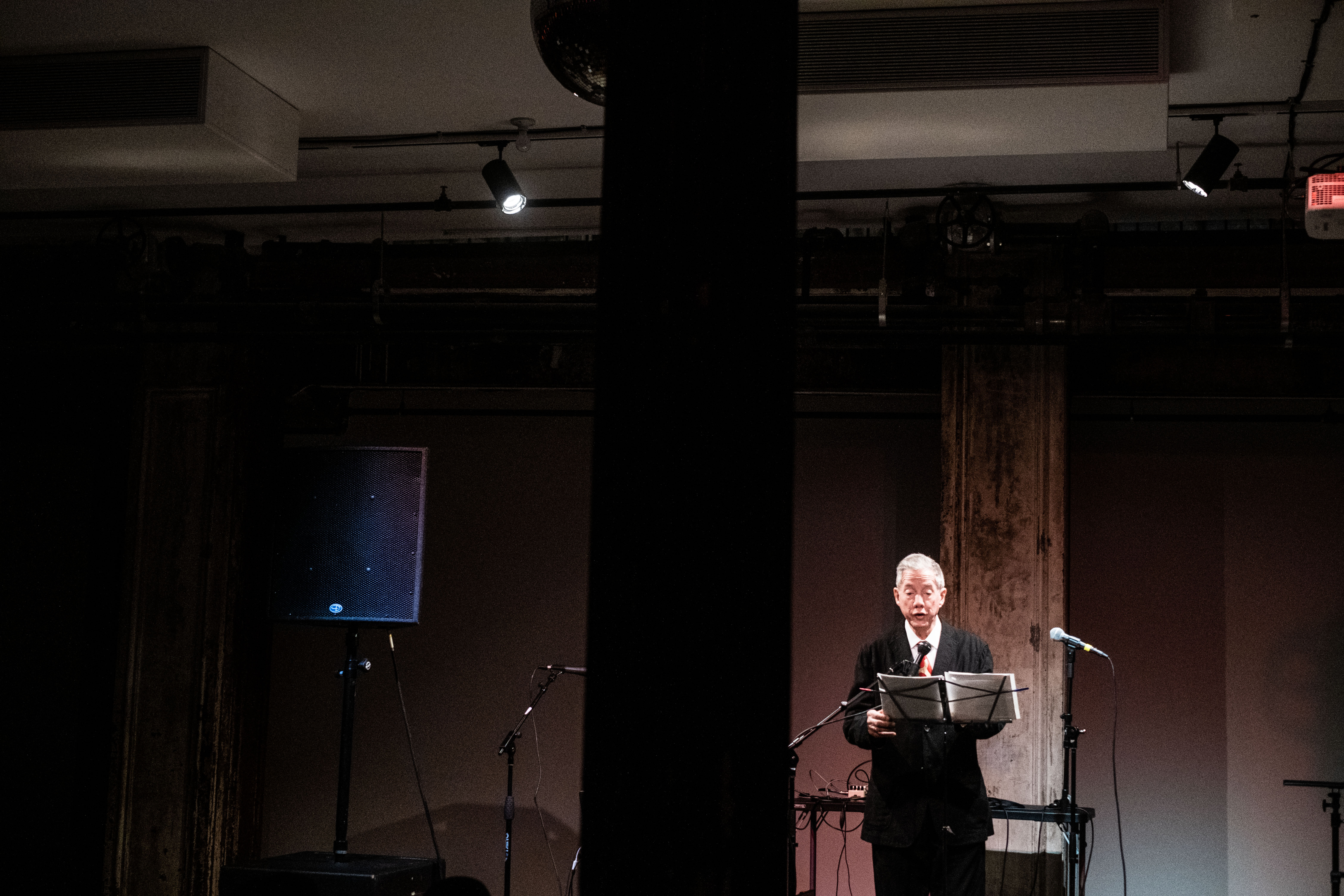 A figure in a suit performs on stage.