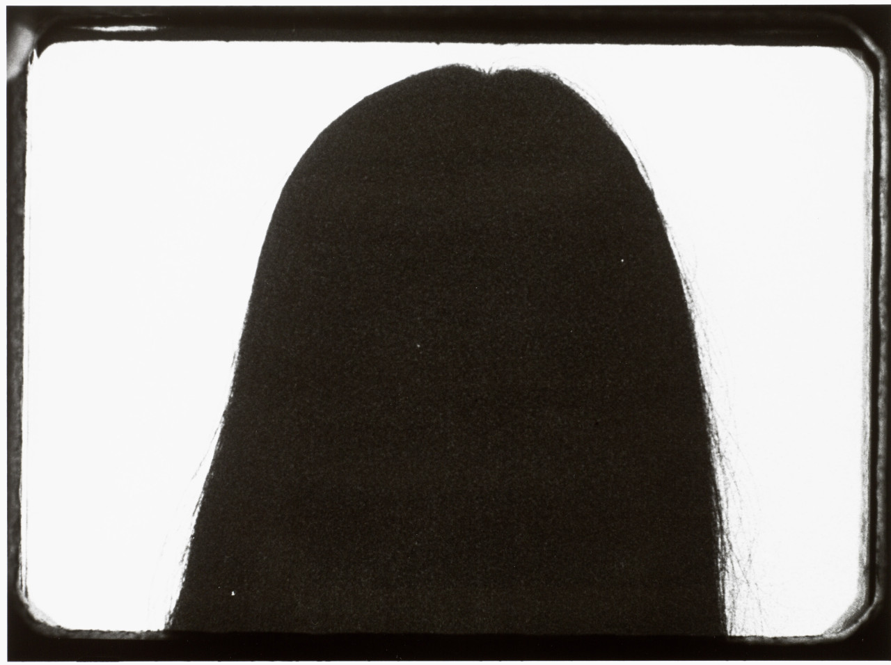 Black-and-white still of the back of a woman's head.