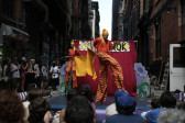 Two figures on stilts appear in motion.