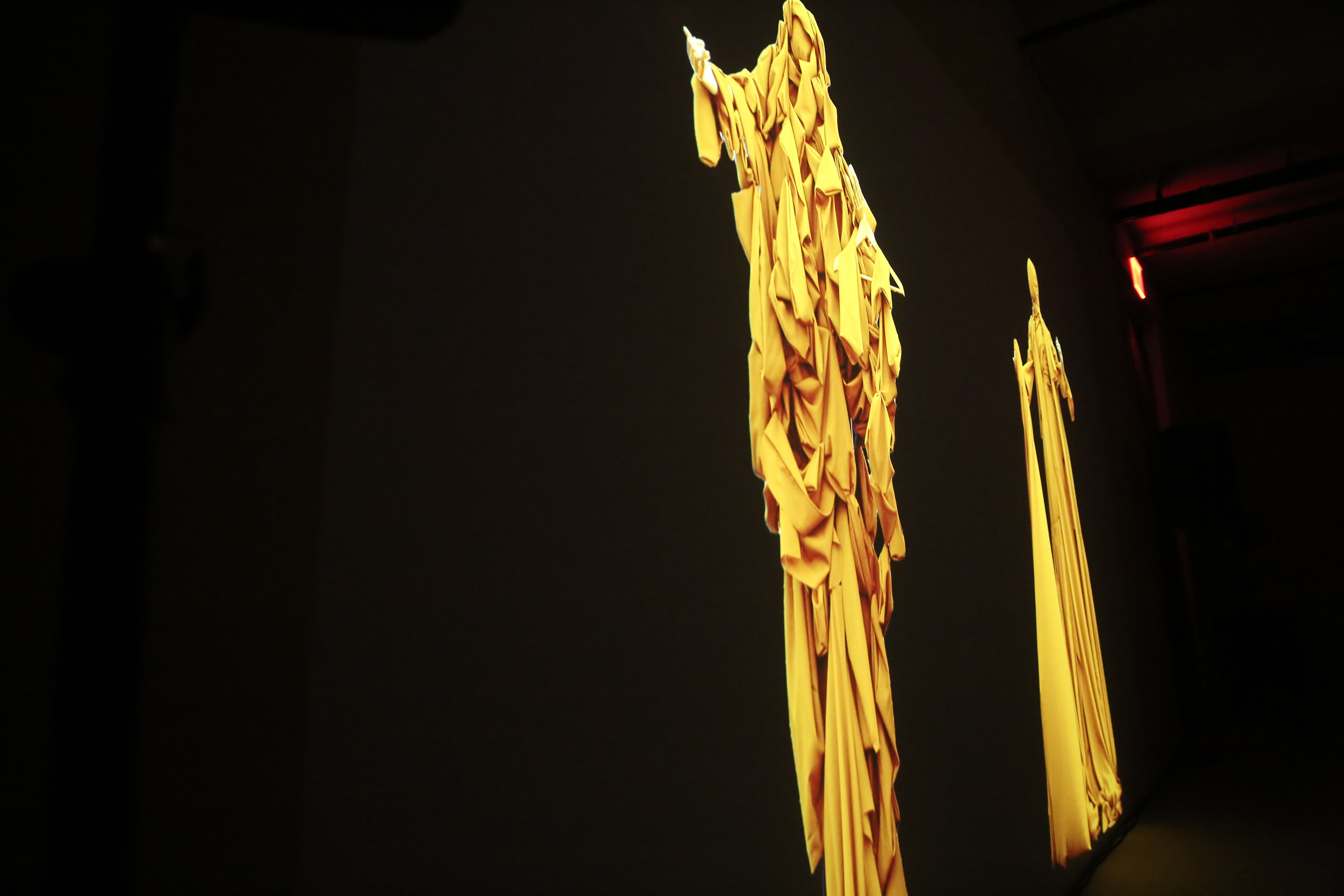 A projection of elongated, yellow-gold figures.