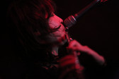 A figure plays the flute into a microphone.