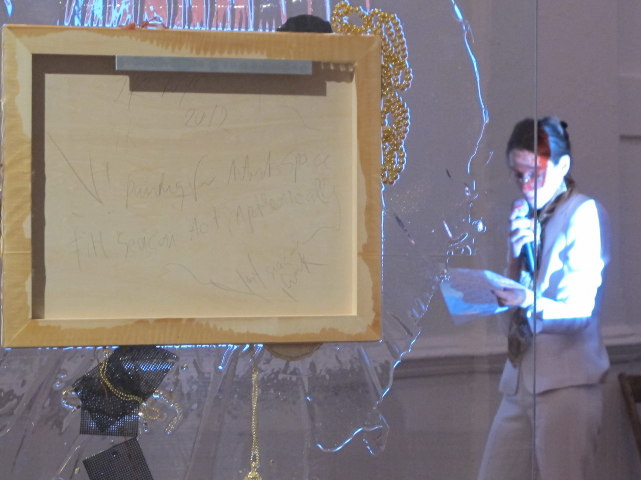 Close up detail of a sculpture composed of a large glass pane with a painted canvas installed in the pane