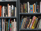 Books packed on two adjacent metal shelving units.