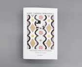 A book sits against a grey background. The cover features a colorful abstract drawing and a black-and-white photograph. The text on the cover reads 