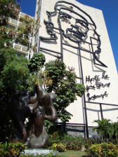 The façade of a building adorned with a large, metal frame sculpture of the face of Che Guevara.
