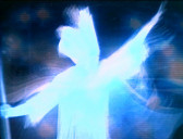 A ghostly, blurry figure in white with their arms out with digital light blurs swirled around.