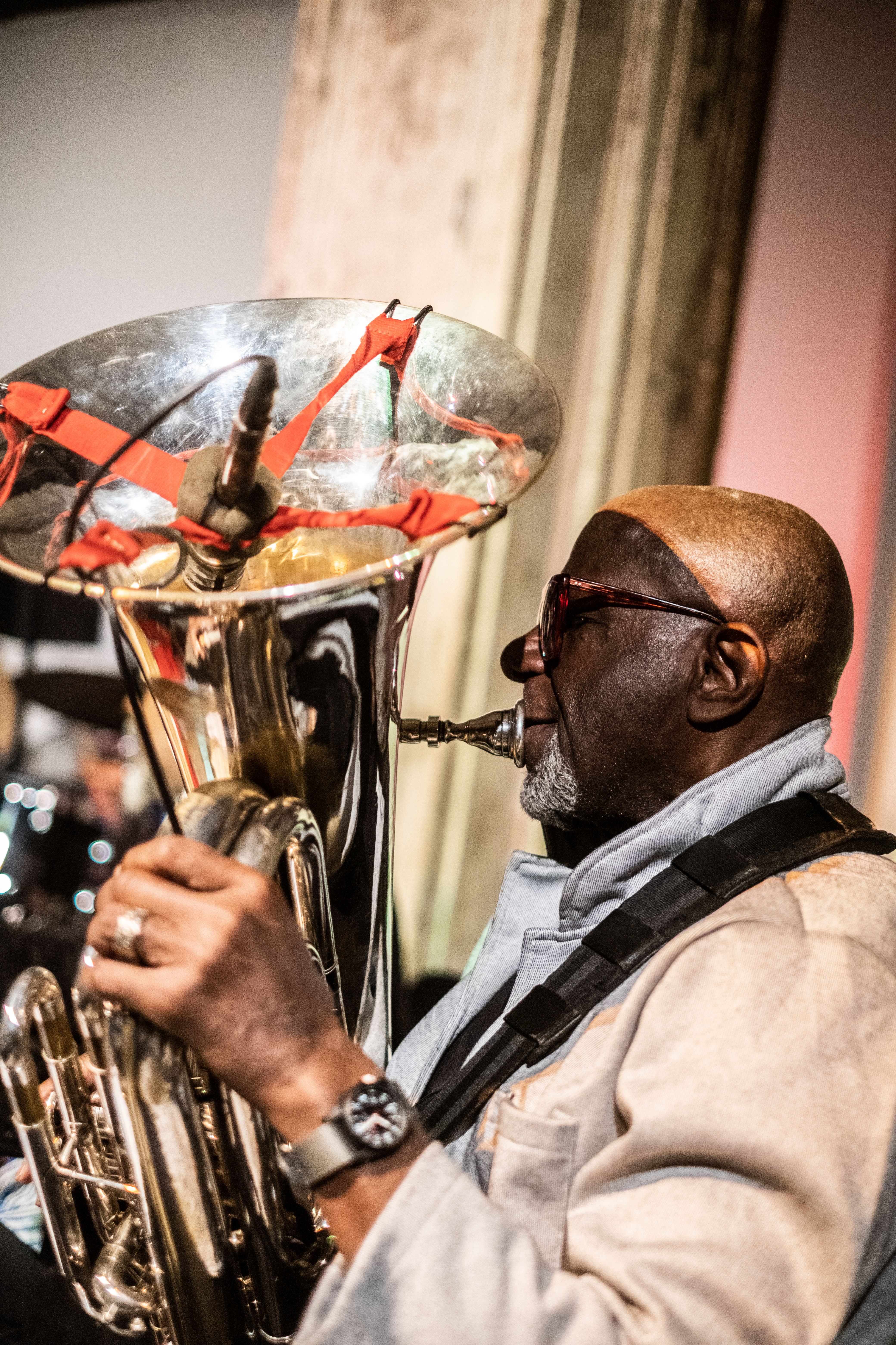 A figure in side profile plays the tuba which has been fitted with a microphone at the bell's opening.