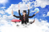 A woman dressed in a suit sits among clouds in a blue sky, smiling, with six arms. Each hand is holding two phones, an alarm clock, globe, laptop, and folder.