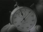 Black-and-white image of a hand holding a stopwatch.