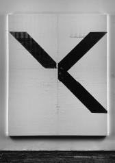 Image of a large white canvas displayed on a white wall. The canvas is rectangular and two faint lines bisect each of its four sides, separating the canvas into four equal quadrants. A black 