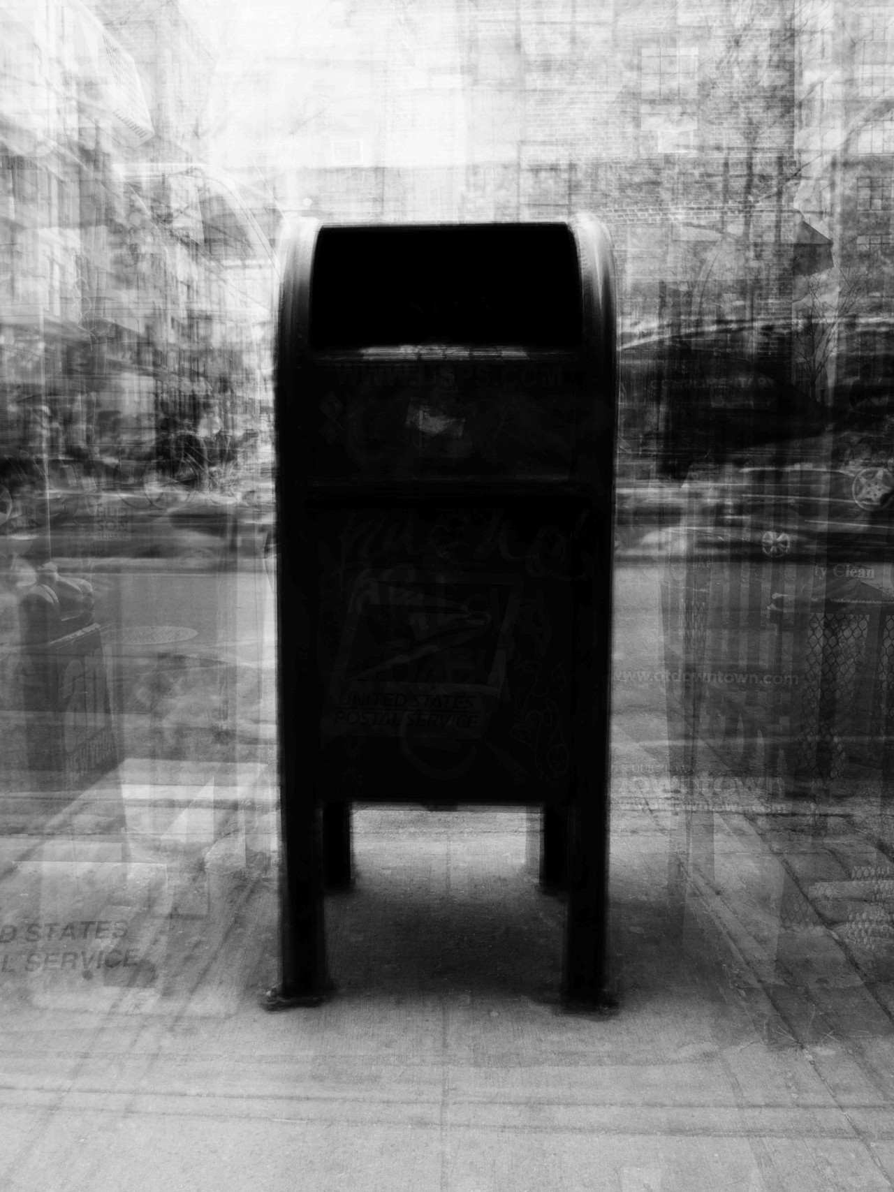 A black and white photo captures a New York City postal service box.