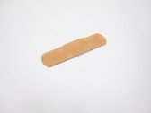 A small, tan bandage lying face-down on a white background.
