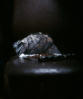 Aluminum foil, partially unrolled, with a pile of pennies is dramatically lit in a darkened room.