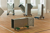 An image of an exhibition space filled with metal square tubes on dolly carts.